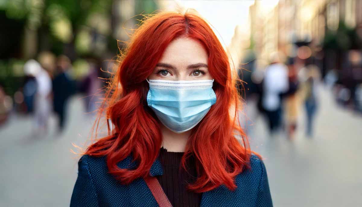 Mulher usando máscara anti-vírus no meio da rua
